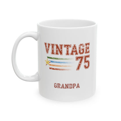 A white ceramic 11oz mug with a printed graphic that reads 'VINTAGE 75 GRANDPA' in distressed red lettering, featuring a retro striped flag design with a small yellow star. Left handle view.