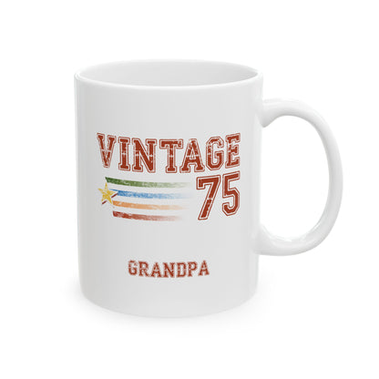A white ceramic 11oz mug with a 'VINTAGE 75 GRANDPA' graphic design featuring a distressed American flag motif and a small yellow star. Right handle view.