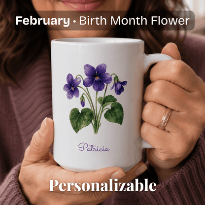 A woman holds a white ceramic mug with violet birth flower and personalized name at bottom.