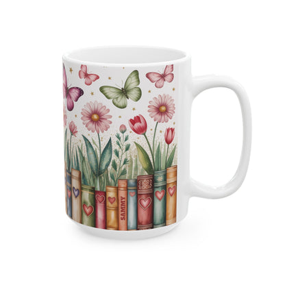 A white ceramic 15oz mug featuring a printed design of vintage book spines decorated with hearts, with flowers and butterflies growing out of them, on a white background. A subtle personalizable name on one of the book spines. Right handle view.